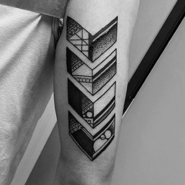 Geometric chevron arrow tattoo in black and grey on the back of the arm, featuring intricate line work and dot shading.