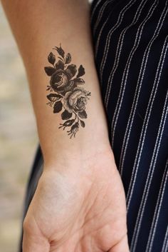 Cute arm tattoos for women: Close-up of a black and white floral forearm tattoo with delicate fine-line flowers, perfect for trending 2025 minimalist designs.