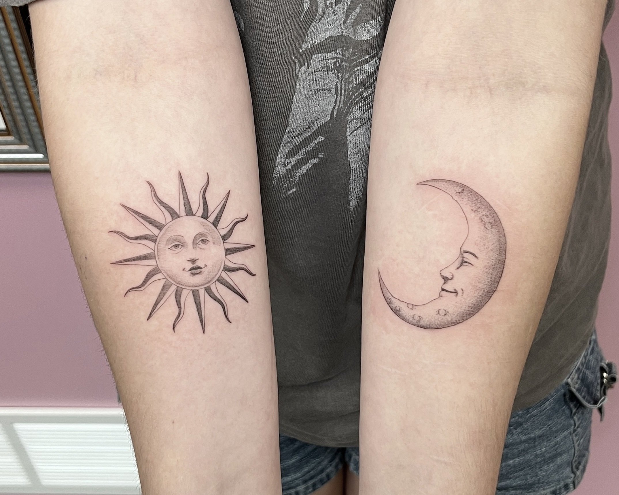 Cute arm tattoos for women featuring matching celestial designs: a detailed, vintage-style sun with a face on the left forearm and a smiling crescent moon with a face on the right forearm. Perfect inspiration for best friend or couple tattoos.